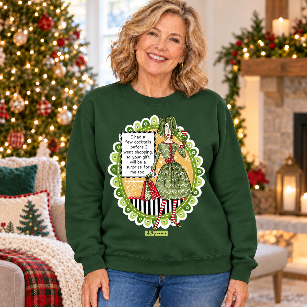 Woman wearing a forest green Dolly Mamas I Had a Few Cocktails sweatshirt beside a decorated Christmas tree and fireplace.