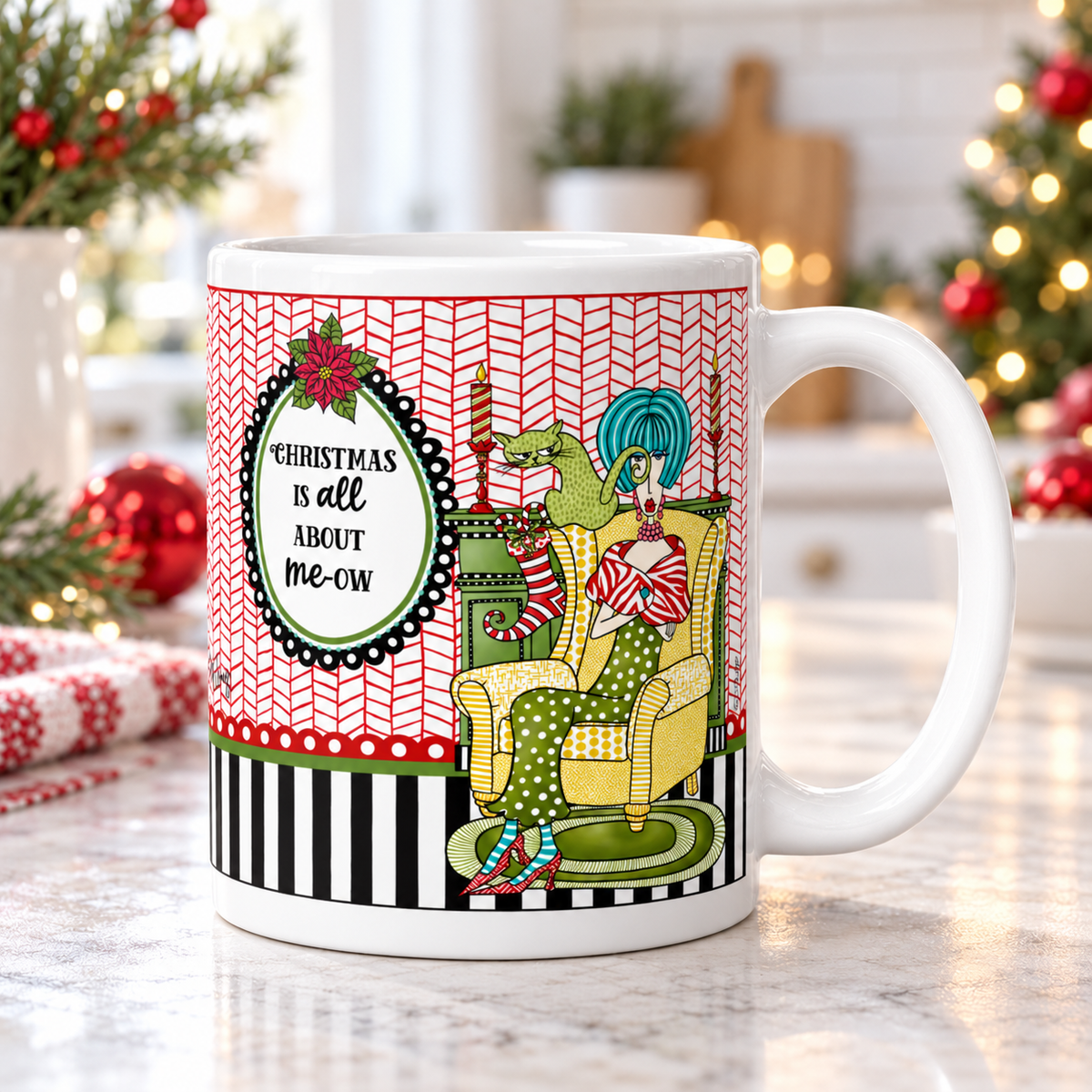 Dolly Mama Christmas cat mug with “Christmas Is All About Me-ow” saying on a kitchen counter, handle on the right, with greenery and red ornaments.