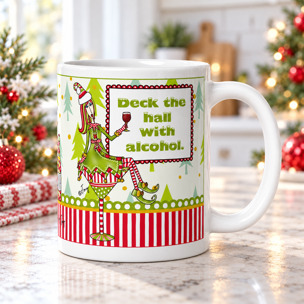 Dolly Mama “Deck the Hall With Alcohol” Christmas mug on a kitchen counter, handle on the right, with Christmas greenery and red ornaments.

