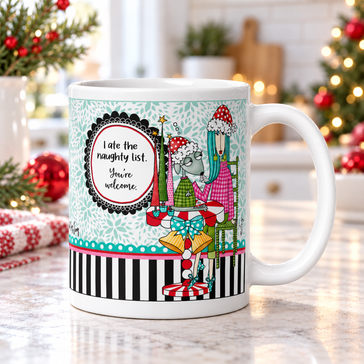 
Dolly Mama “I Ate the Naughty List. You’re Welcome.” mug on a kitchen counter, handle right, with Christmas greenery and red ornaments.
